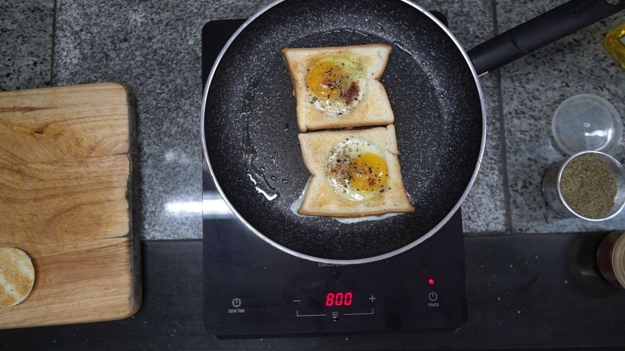 Eggs in toasted bread with herbs and ground paprika.
